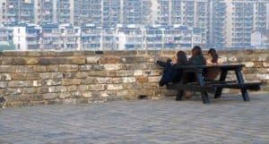 Three friends put their feet up on the Nanjing city wall.